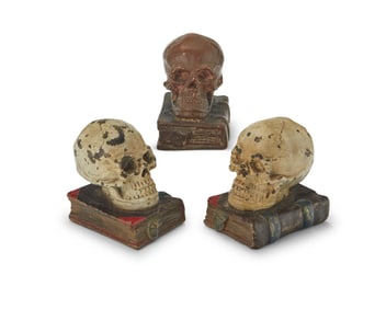 Three bronzed plaster skull-form bookends