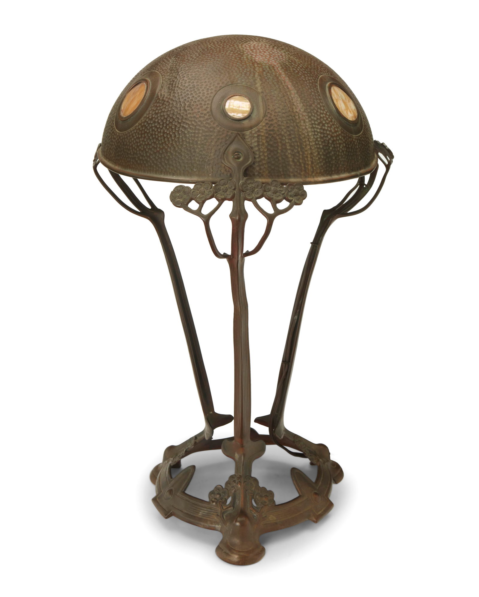 An Austrian Secessionist table lamp: An Austrian Secessionist table lampEarly 20th centuryUnmarkedThe hammered copper single-light lamp with mother of pearl inset accents to shade, raised on floriform supports, electrified17.5" H x 11" D