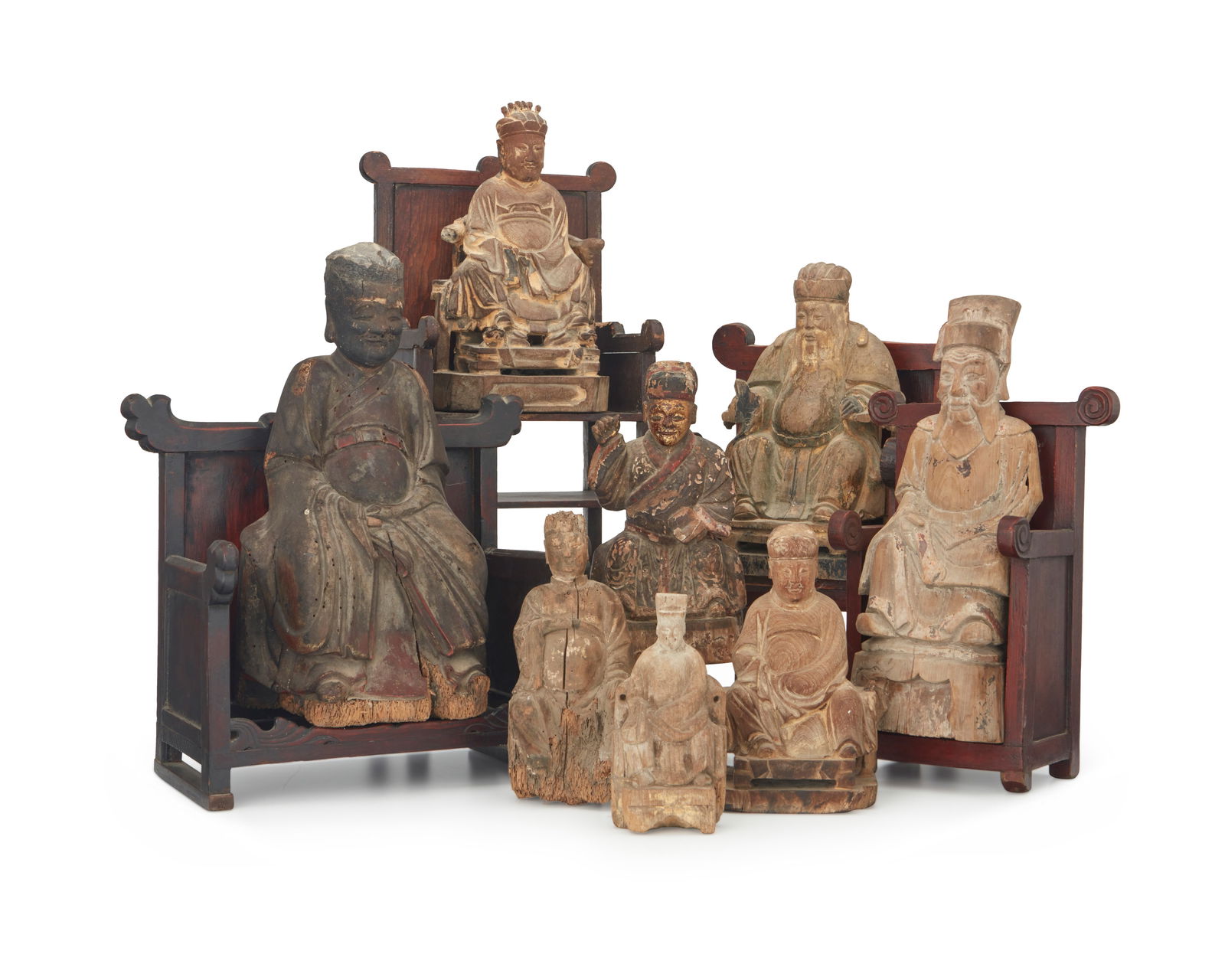 A group of Asian carved wood deity figures: A group of Asian carved wood deity figures19th/20th centuryComprising eight figures, some with polychrome or gilt remnants, and four chairs12 piecesLargest deity: 14" H x 7.5" W x 6.5" D; Largest chai