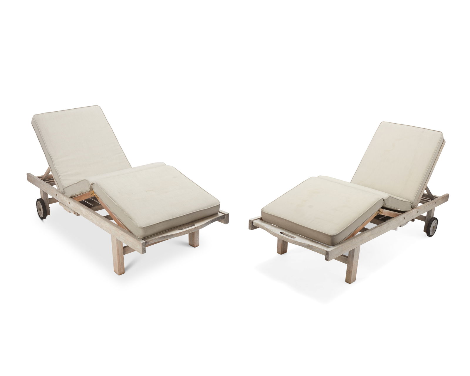 A pair of Contemporary teak chaise lounge chairs: A pair of Contemporary teak chaise lounge chairsEarly 21st centuryEach unmarkedEach with adjustable recliners and leg supports, featuring a food serving tray stored beneath the seat, with weather-resi