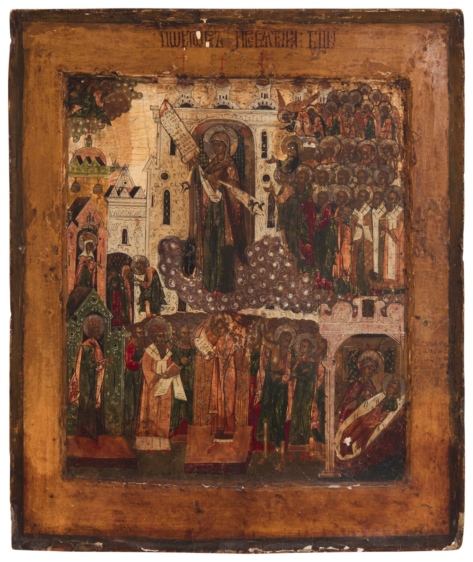 A Russian Icon, Mother of God, Pockrov: A Russian Icon, Mother of God, Pockrov19th centuryWith paint and gold leaf on a wood panel depicting the Mother of God with various saints and figures in a town scene; with a painted inscription in Cy
