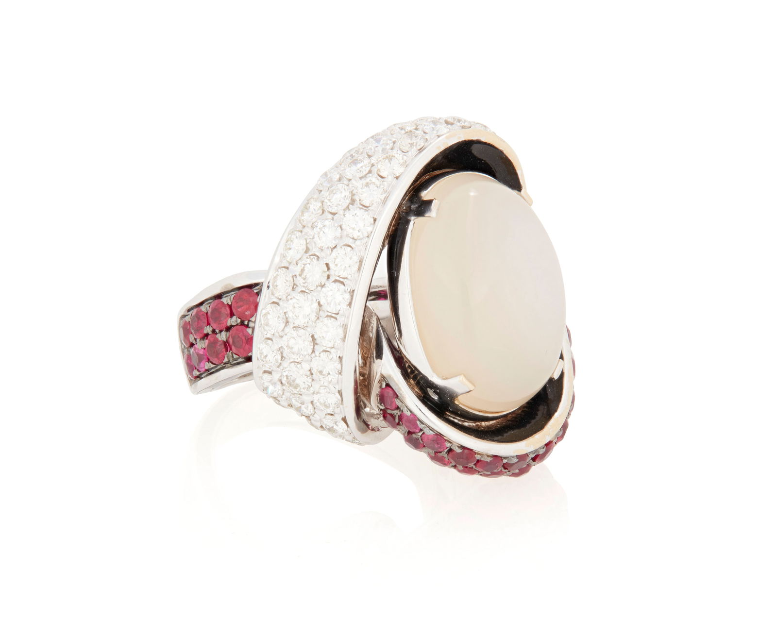 An 18K White Gold, Moonstone, Ruby and Diamond Ring: An 18K White Gold, Moonstone, Ruby and Diamond RingFeaturing an oval moonstone cabochon measuring approximately 17.46 x 13.10 mm, accented by round rubies and diamondsSize: 7 1/424.2 grams gross