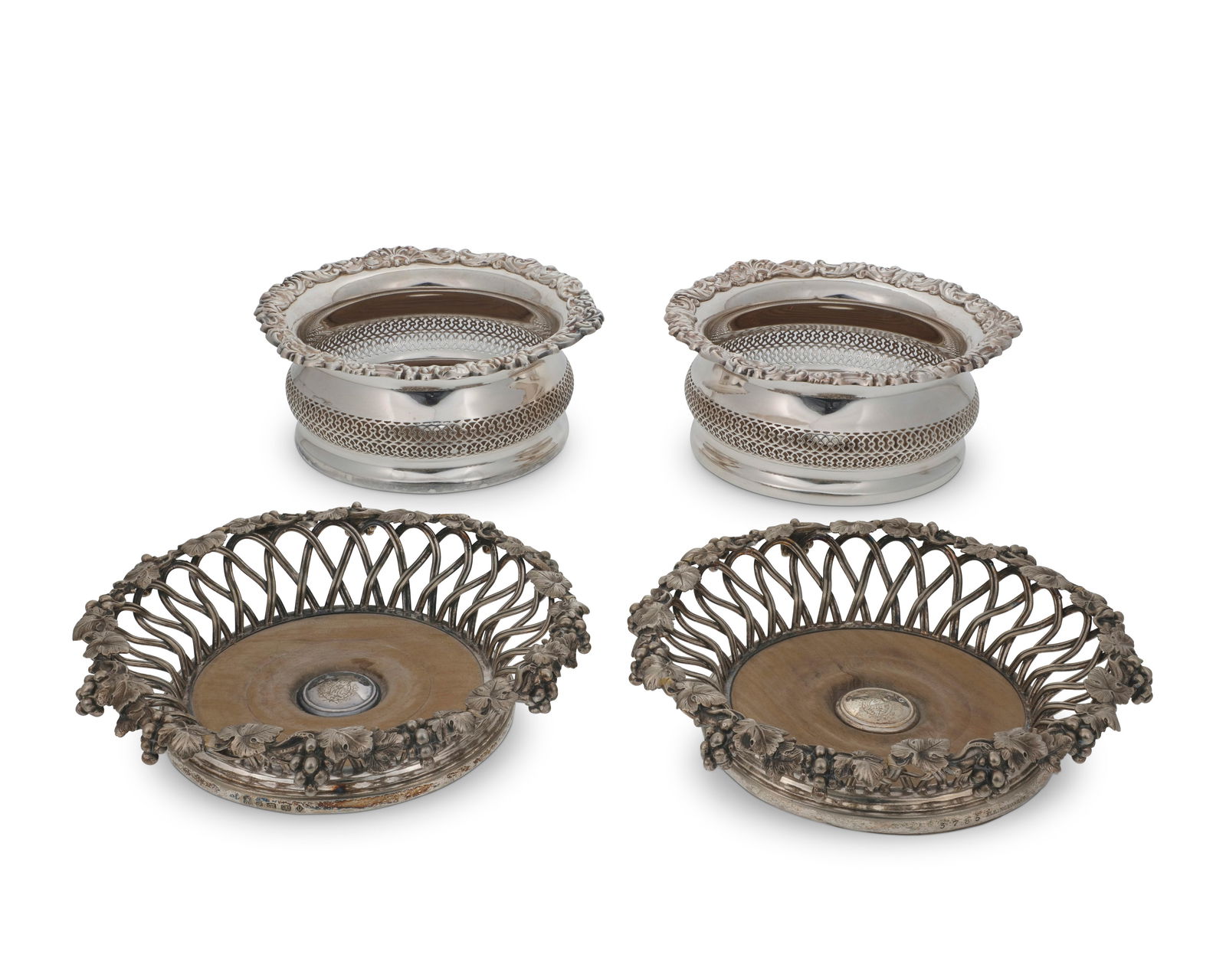 Two pairs of silver-plated wine bottle coasters: Two pairs of silver-plated wine bottle coasters19th/20th centuryOne pair with maker's marks of Elkington, Mason & Co., Birmingham, dated for 1859; also bearing an armorial at centerComprising an Elkin