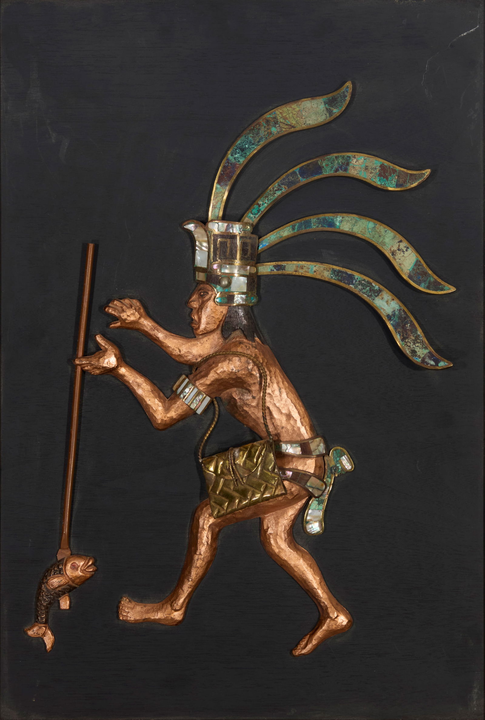 A Los Castillo Mayan/Aztec style copper and hardstone wall panel: A Los Castillo Mayan/Aztec style copper and hardstone wall panelMid/late 20th/early 21st centuryUnmarkedThe hand-wrought copper and brass figure depicted spearing a fish, with inlaid green hardstone a