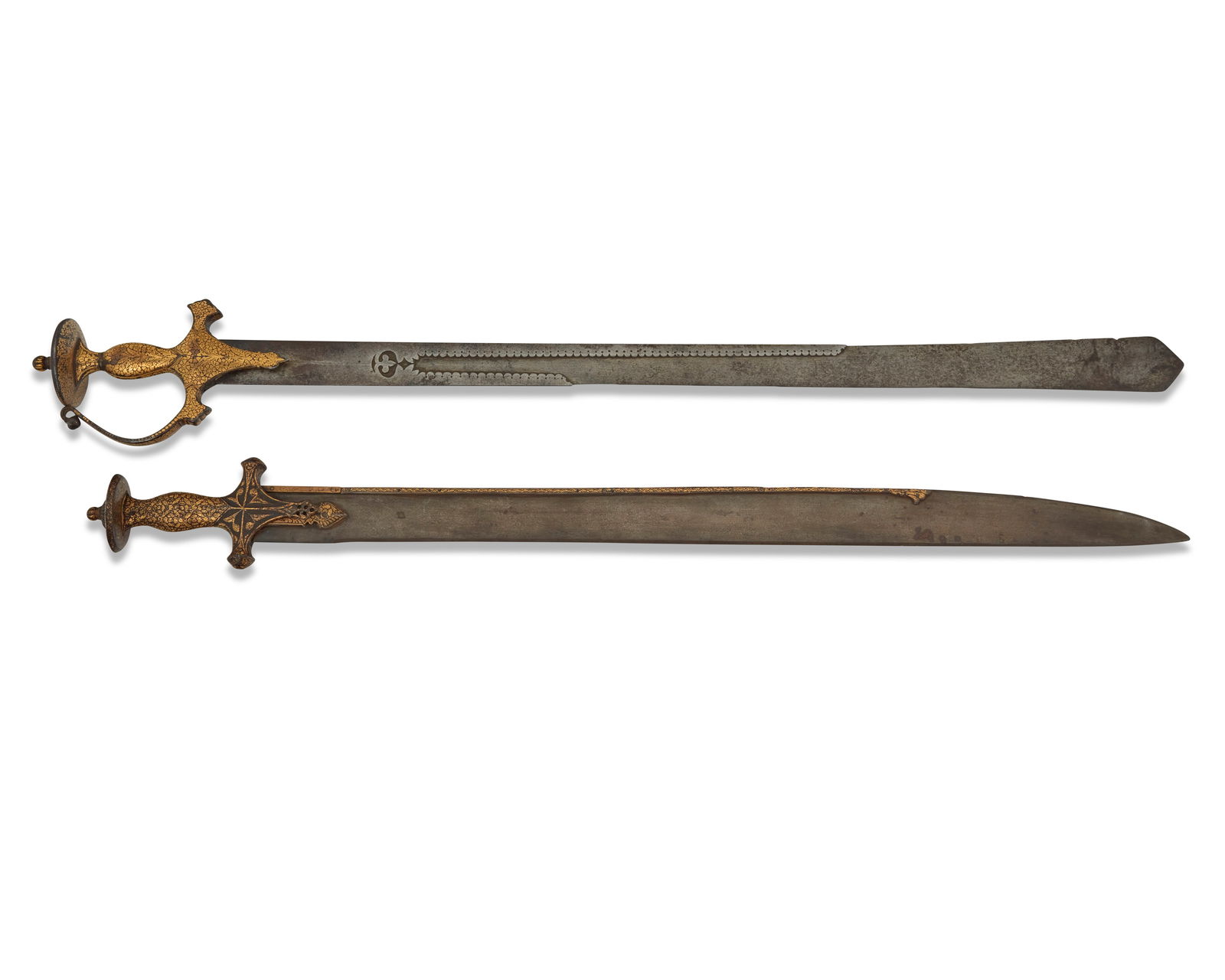 Two Indian 'tulwar' swords: Two Indian 'tulwar' swords17th/18th centuryOne with gilt inscription along blunt end of bladeEach with gilt hilt2 piecesLarger: 36" L, blade 30" L, hilt 5" W; Shorter: 33" L, blade 27.5" L, hilt 3.375