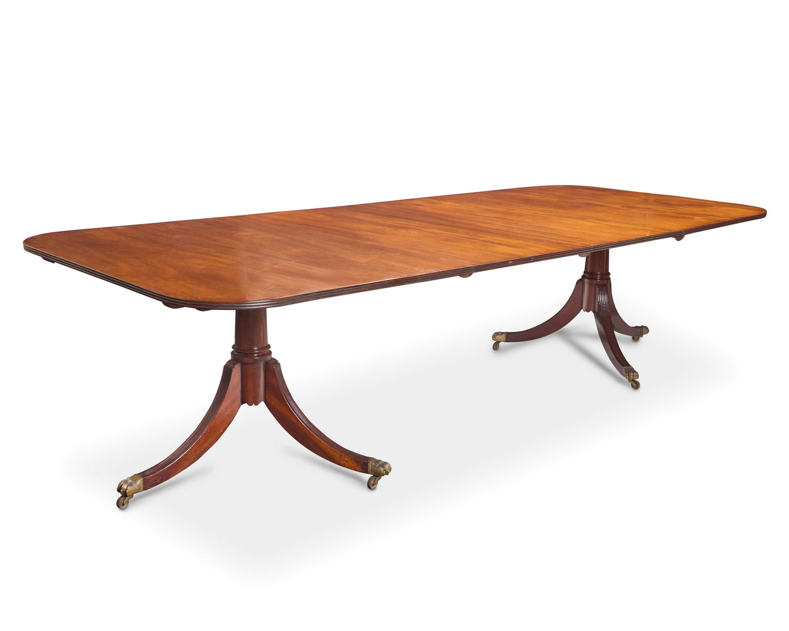 A George III style mahogany twin pedestal extension dining table: A George III style mahogany twin pedestal extension dining table Late 20th century Each pedestal with applied label to underside: Made in England Each side raised on a three-legged pedestal