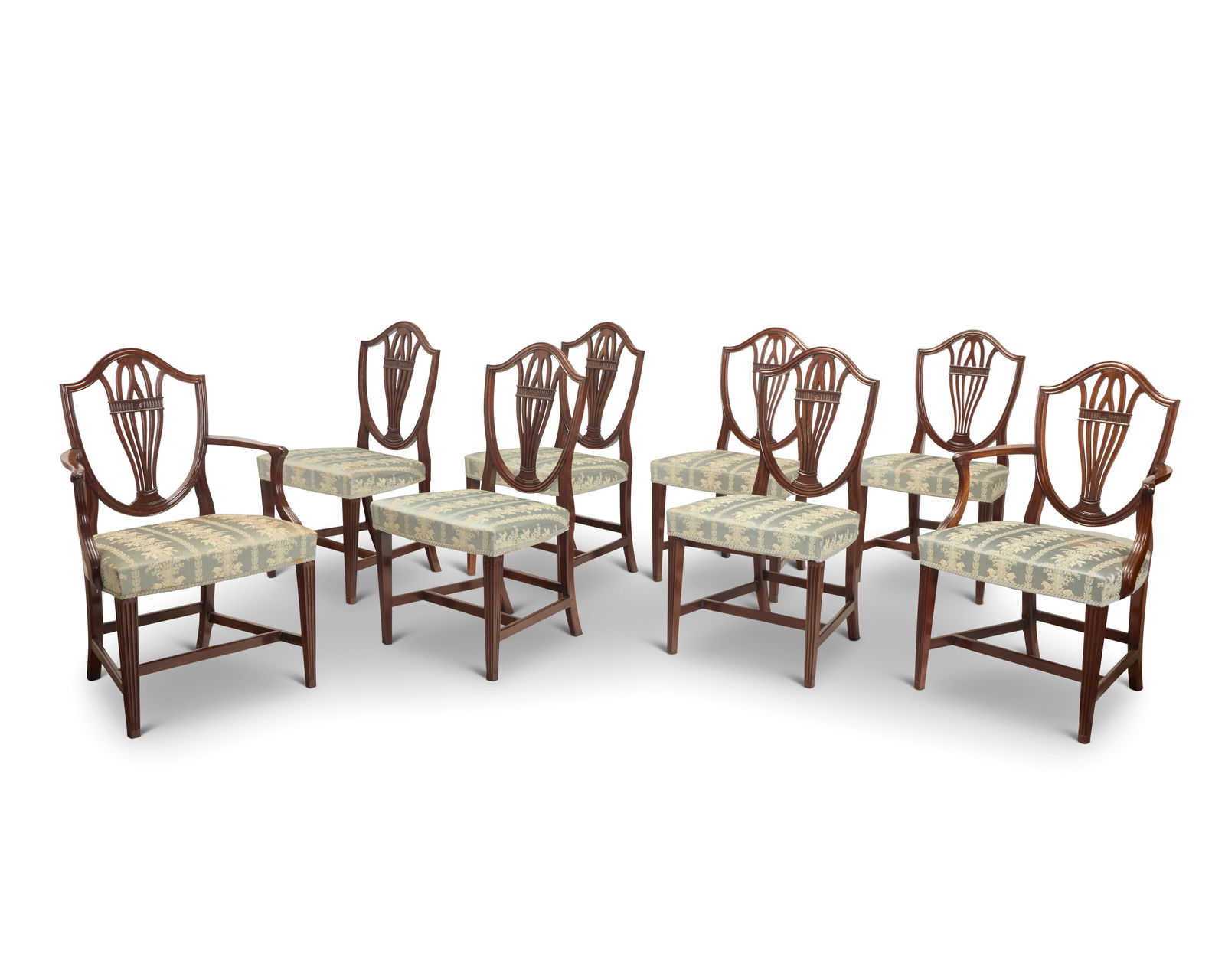 A set of eight George III style mahogany dining chairs: A set of eight George III style mahogany dining chairs Early 20th century Each with shield-back and seat upholstered in a floral pattern fabric with passementerie trim, comprising two armchairs and