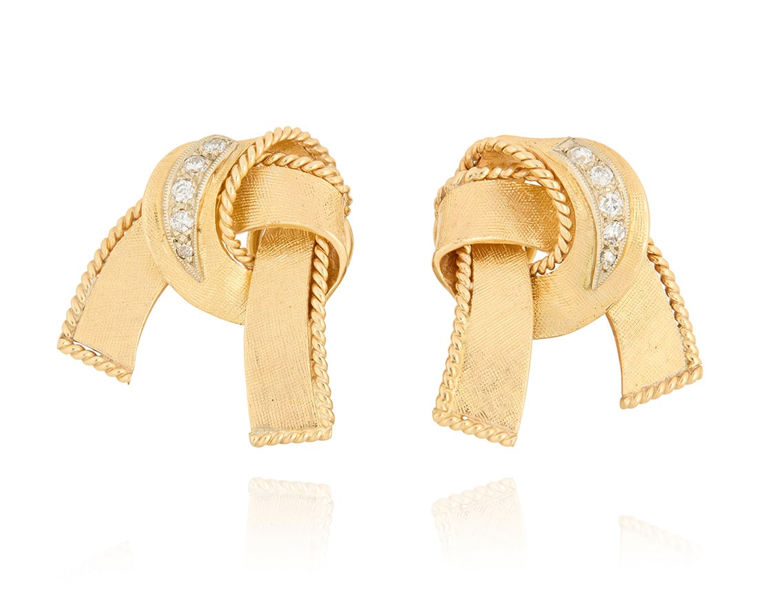 A Pair of 14K Gold and Diamond Earclips: A Pair of 14K Gold and Diamond Earclips Of a bow design with rope accents, set with round diamonds weighing approximately 0.26 carats 2 pieces Measures: 7/8 x 3/4 in. 10.6 grams gross