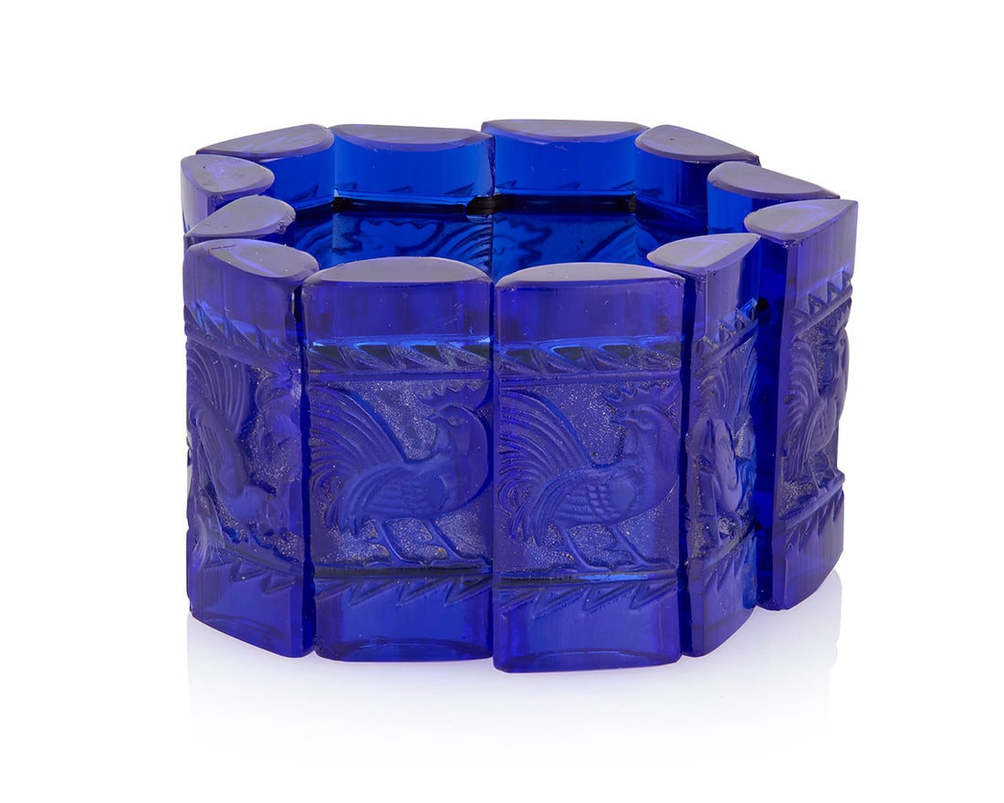 Rene Lalique: A Blue Glass "Coq" Bracelet, c. 1928: Rene Lalique: A Blue Glass "Coq" Bracelet, c. 1928 A bracelet 'extensible' consisting of twelve rectangular, half-cylinder shaped dark blue glass tablets, strung together with elastic, and each link