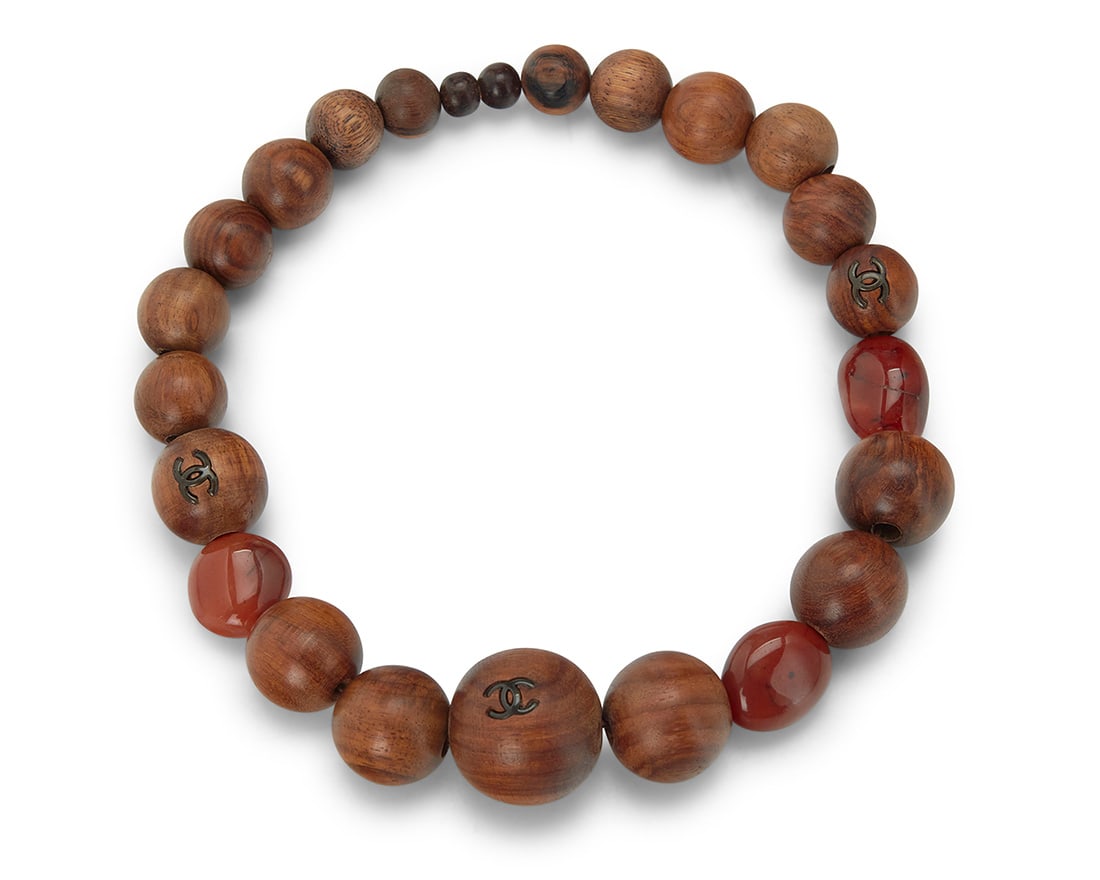 CHANEL: A Wood and Carnelian Bead Necklace, 1998: CHANEL: A Wood and Carnelian Bead Necklace, 1998 The chunky collar necklace of graduated round wood beads interspersed with three large carnelian beads, with CC logo to two beads and fine screw