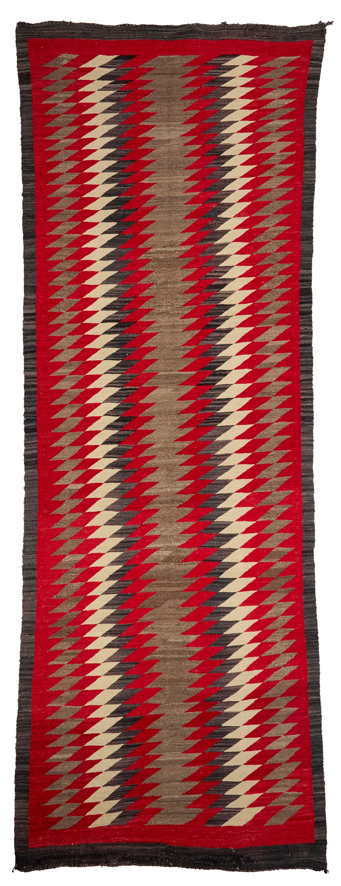 A large Navajo regional runner Early 20th century, Dine Woven in red, cream, natural grey, and: A large Navajo regional runner Early 20th century, Dine Woven in red, cream, natural grey, and dark brown wool, with alternating serrated vertical bands 124" L x 44" W