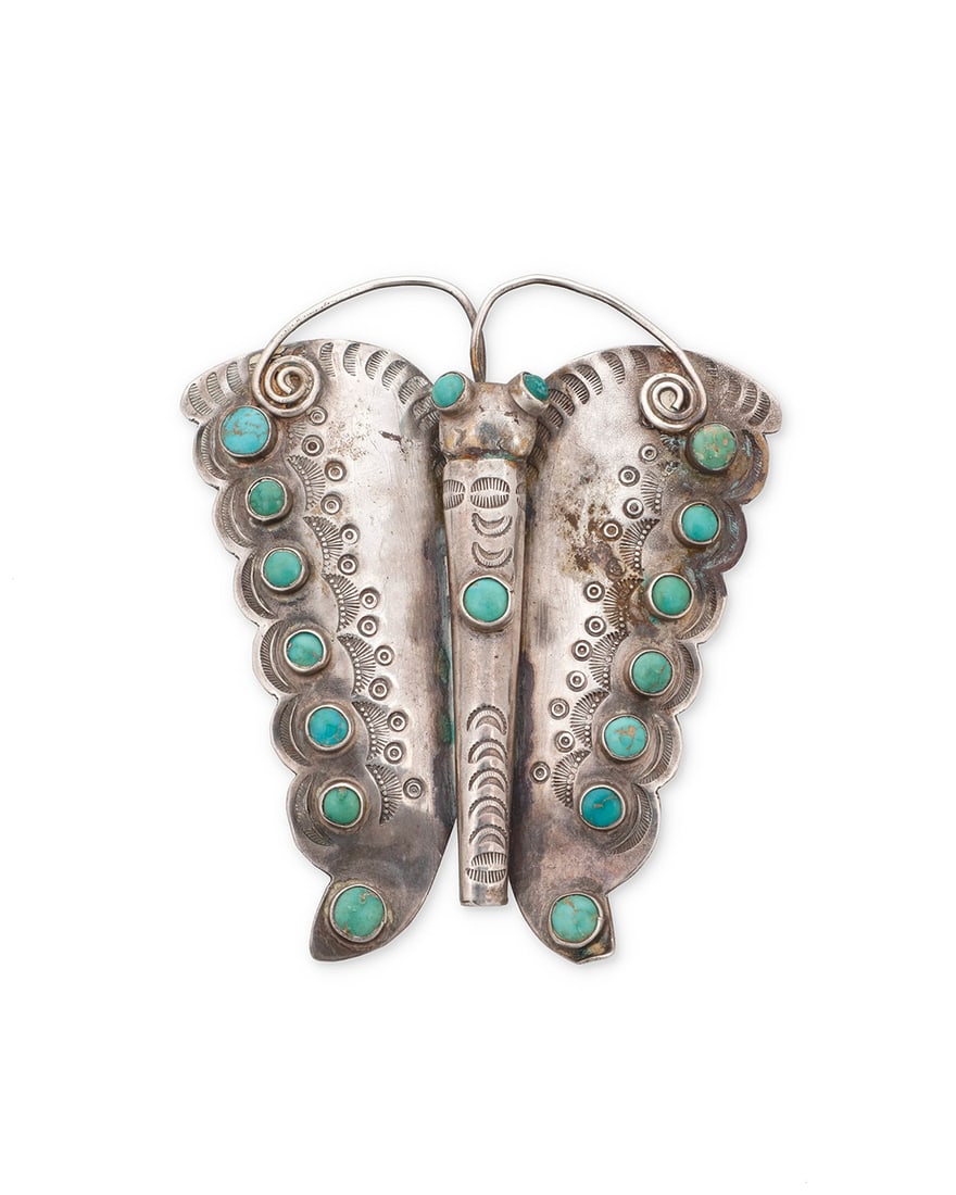 A Southwest style sterling silver and turquoise butterfly pendant/brooch: A Southwest style sterling silver and turquoise butterfly pendant/brooch Mid-20th century Unmarked A large pendant/brooch with small turquoise cabochons, stamped accents, and silver wire features 3"