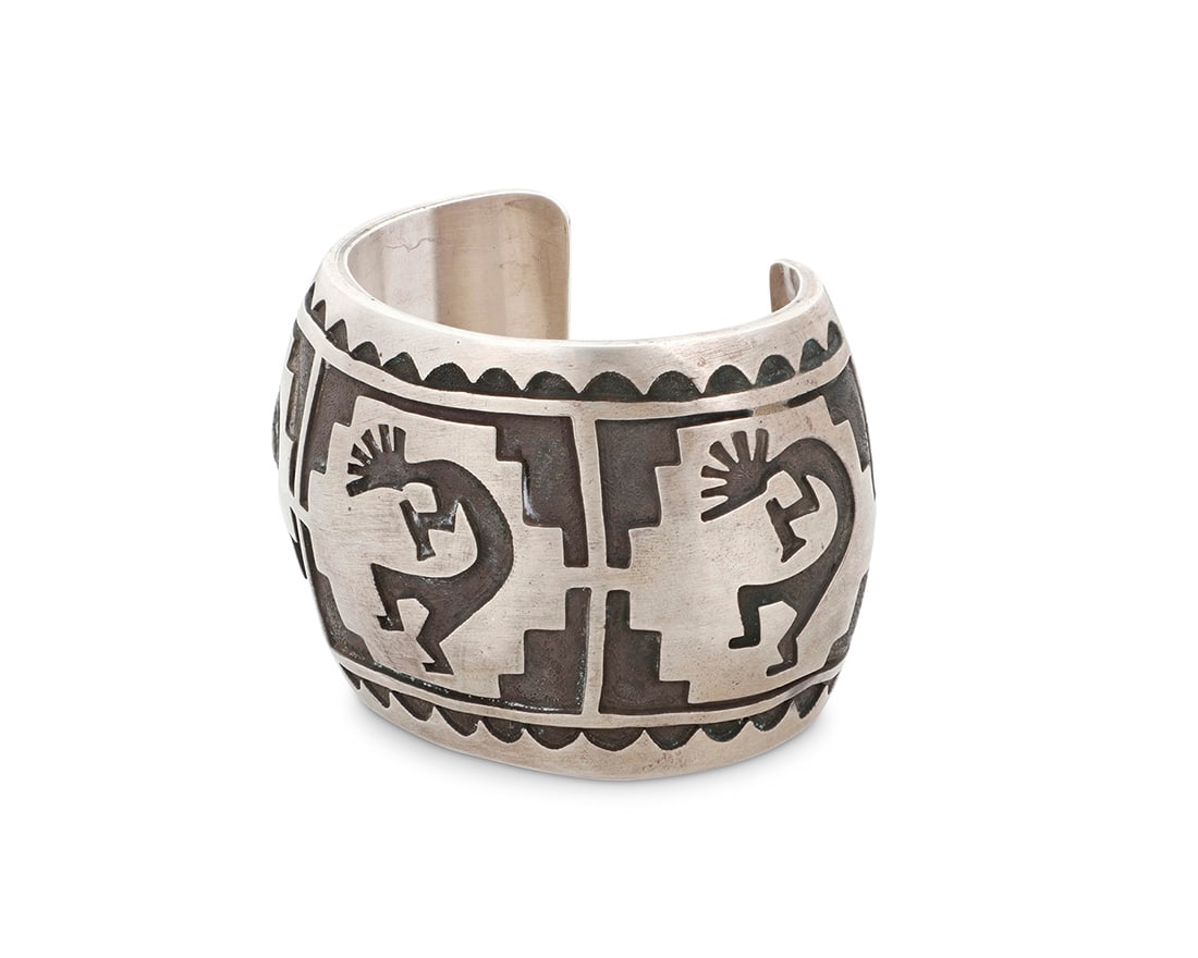 A Hopi Pueblo style Southwest sterling silver overlay cuff with Kokopelli: A Hopi Pueblo style Southwest sterling silver overlay cuff with Kokopelli Late 20th century Unknown mark to interior: W A chunky overlay cuff with three Kokopelli motifs and geometric motifs 6" inner