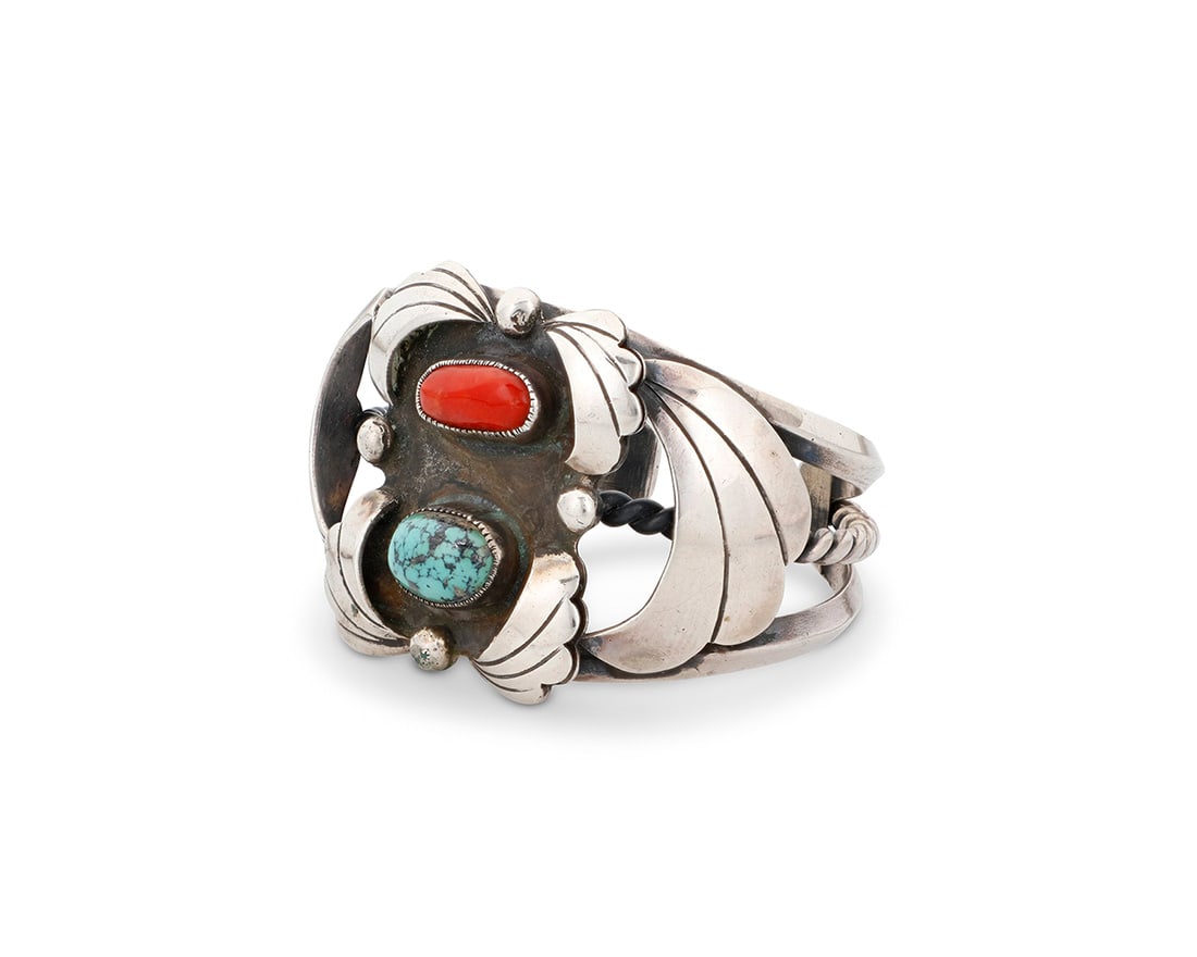 An Alfred Joe Navajo sterling silver and set stone cuff bracelet: An Alfred Joe Navajo sterling silver and set stone cuff bracelet Alfred Joe (b. 1950, Dine) Late 20th/21st century Stamped: AJ [conjoined] A chunky three-wire cuff with central plaque set with coral