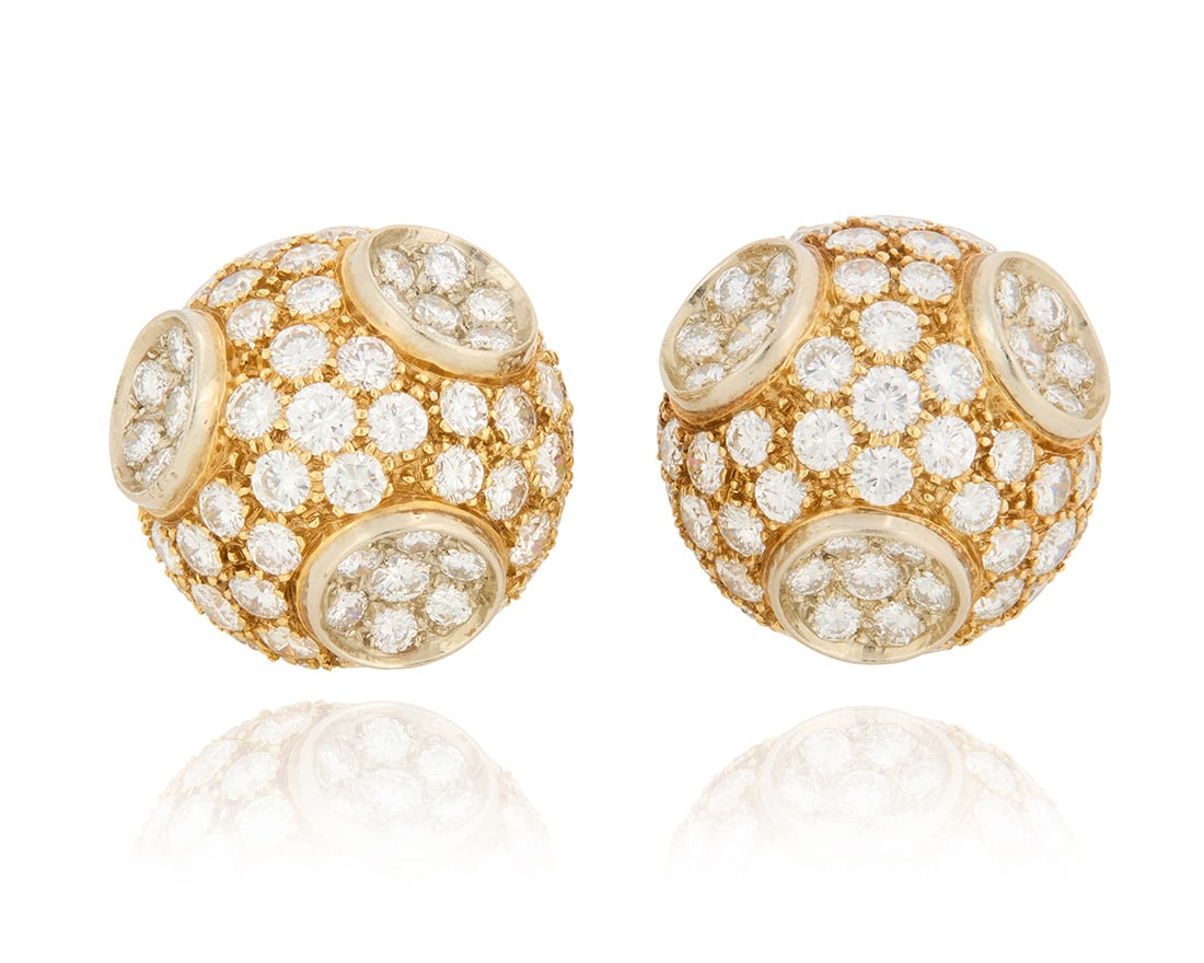 A Pair of Bi-Color Gold and Diamond Earclips: A Pair of Bi-Color Gold and Diamond EarclipsOf a dome design featuring white and yellow gold set with round diamonds weighing approximately 7.00 carats2 piecesMeasures: 3/4 in.17.0 grams grossPro