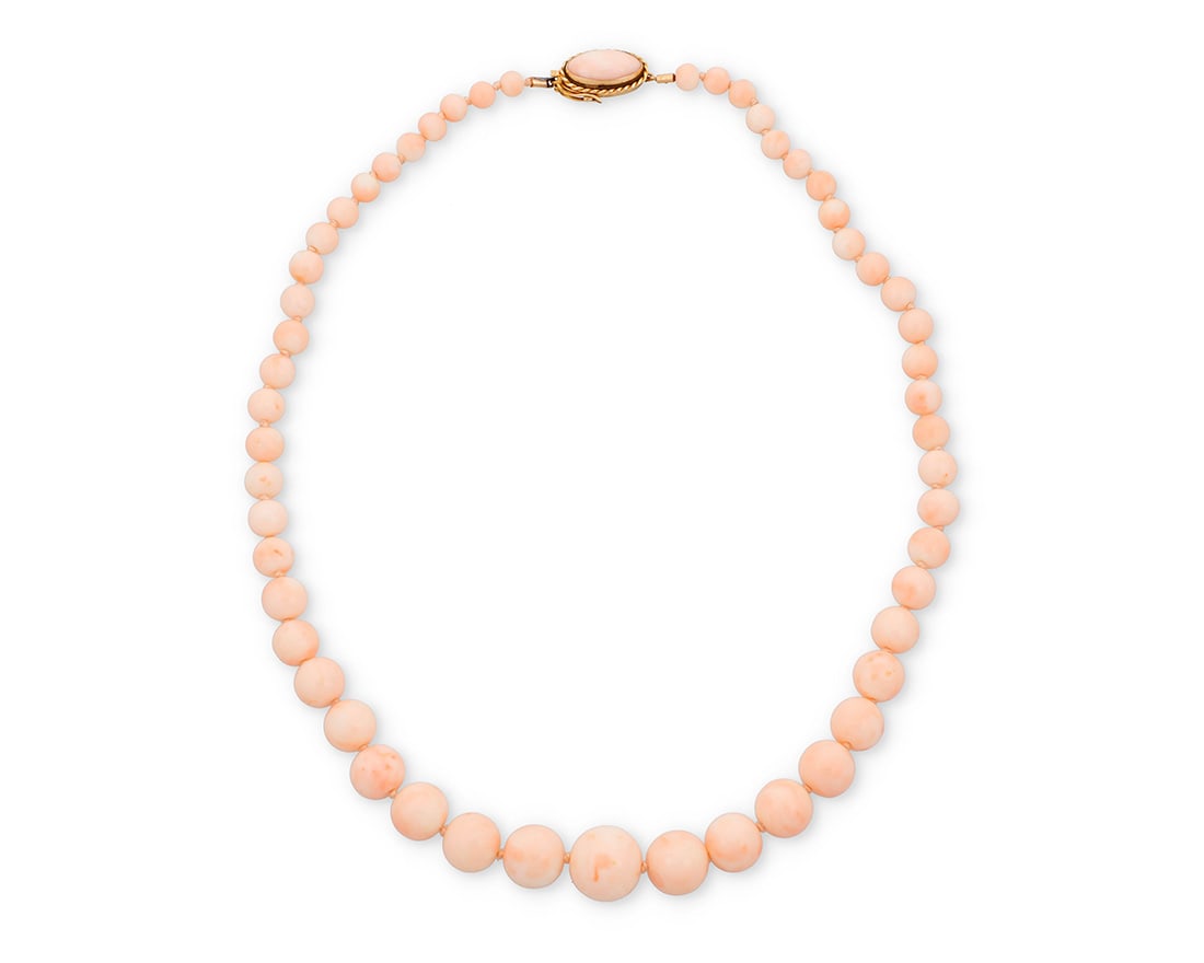 An 18K Gold and Coral Necklace: An 18K Gold and Coral NecklaceOf a single strand design featuring graduated round coral beads measuring approximately 6.31 - 16.72 mm, finished with an 18k gold and coral claspLength: 22 1/2 in.84.4 g