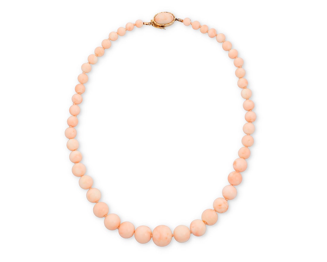 An 18K Gold and Coral Necklace: An 18K Gold and Coral NecklaceOf a single strand design featuring graduated round coral beads measuring approximately 6.78 - 16.84 mm, finished with an 18k gold and coral claspLength: 20 1/2 in.80.8 g