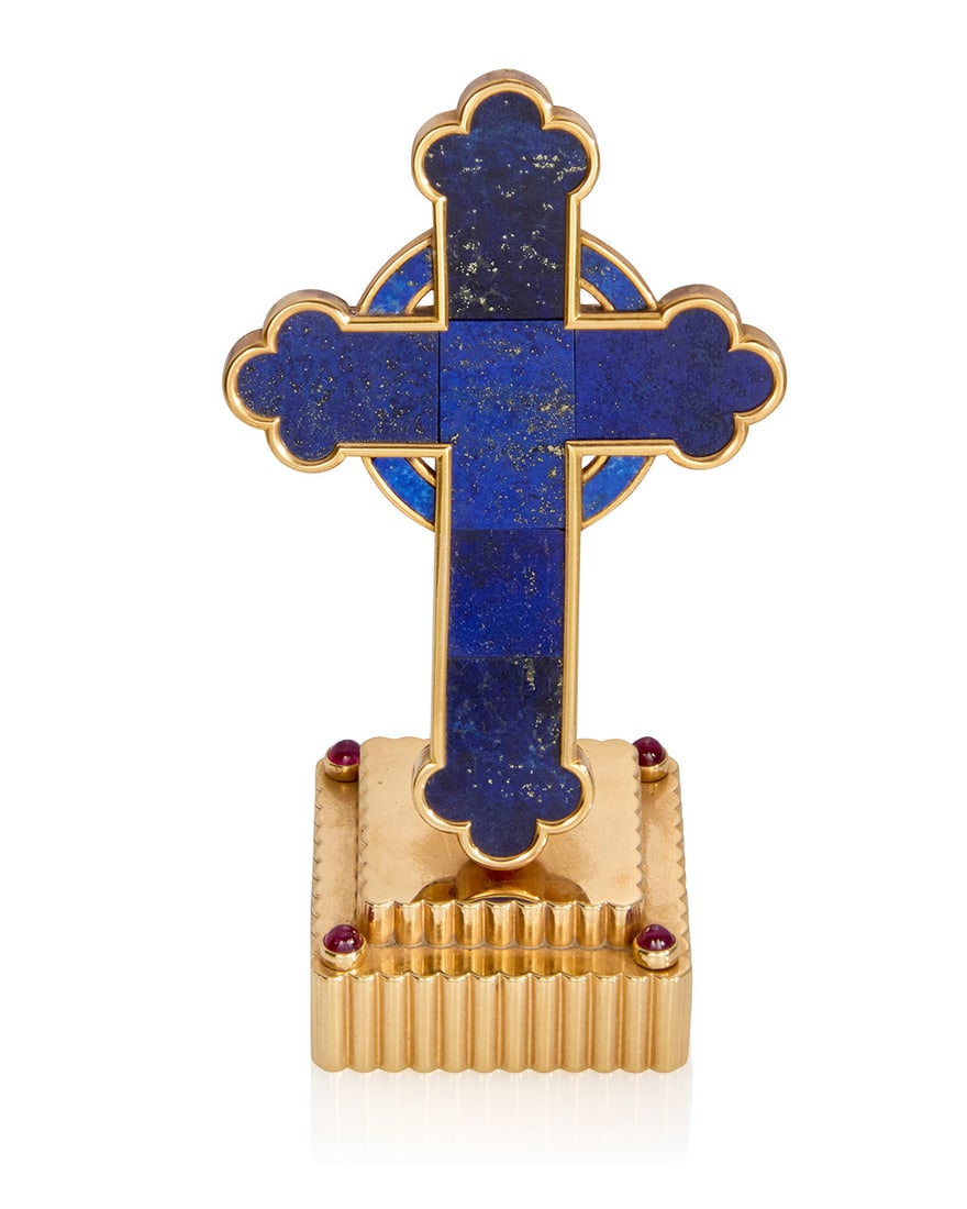 Cartier: A 14K Gold, Lapis Lazuli and Ruby Cross: Cartier: A 14K Gold, Lapis Lazuli and Ruby CrossOf a cross design featuring panels of carved lapis lazuli, set upon a tiered square fluted gold mount accented by four round ruby cabochons, inscribed o