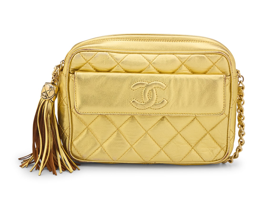 CHANEL: A Metallic Gold Quilted CC Pocket Camera Bag: CHANEL: A Metallic Gold Quilted CC Pocket Camera BagStamped to interior: Chanel / ® / Made in ItalyA vintage rectangular gold lurex fabric/leather crossbody bag with exterior flap pocket, large fring