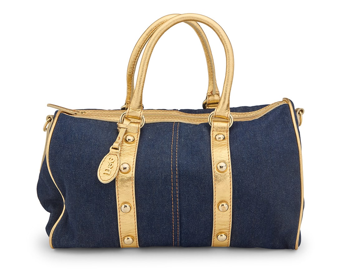 Dolce & Gabbana: A Blue Denim & Gold Leather Tote Bag: Dolce & Gabbana: A Blue Denim & Gold Leather Tote BagCirca 2007A medium bowling-style soft zip-top tote in washed dark denim with gold metallic leather straps and trim with gold-toned studs, hardware,