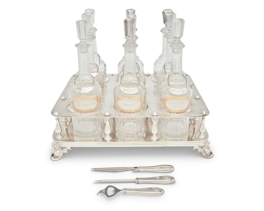 An Armand Frenais silver plated spirits bottle holder and glass bottles: An Armand Frenais silver plated spirits bottle holder and glass bottlesLate 19th/early 20th century; FranceHolder marked: A. Frenais / BLANC70 / AF [anchor cipher] / 70; each tag marked: Sterling / R