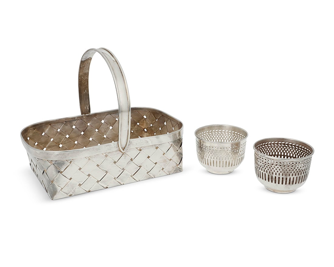 Three Cartier sterling silver table items: Three Cartier sterling silver table itemsMid-20th centuryEach with impressed factory marks; basket and one cup marked: STERLING; the other cup XRF tested for sterling; basket further marked: Handmade;
