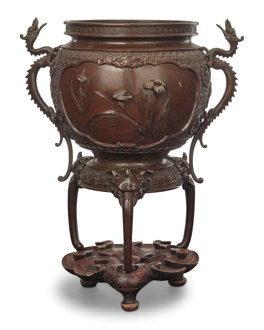 A Japanese patinated bronze censer: A Japanese patinated bronze censerMeiji/Taisho Period (1868-1926)Unknown impressed mark to undersideWith dragon-form handles and elephant-form tripod feet, raised on a carved hardwood standCenser: 12.