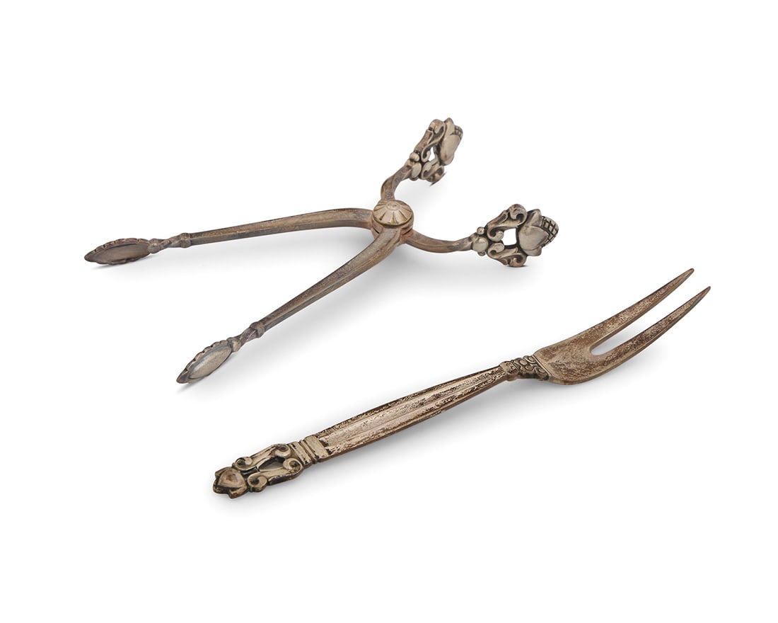A Georg Jensen sterling silver 'Acorn' sugar tongs and a date fork: A Georg Jensen sterling silver 'Acorn' sugar tongs and a date forkCirca 1930sIntroduced 1915With impressed factory marks and: STERLING / DENMARKHoused in a fitted box2 piecesTongs: 4.125" L; Date fork