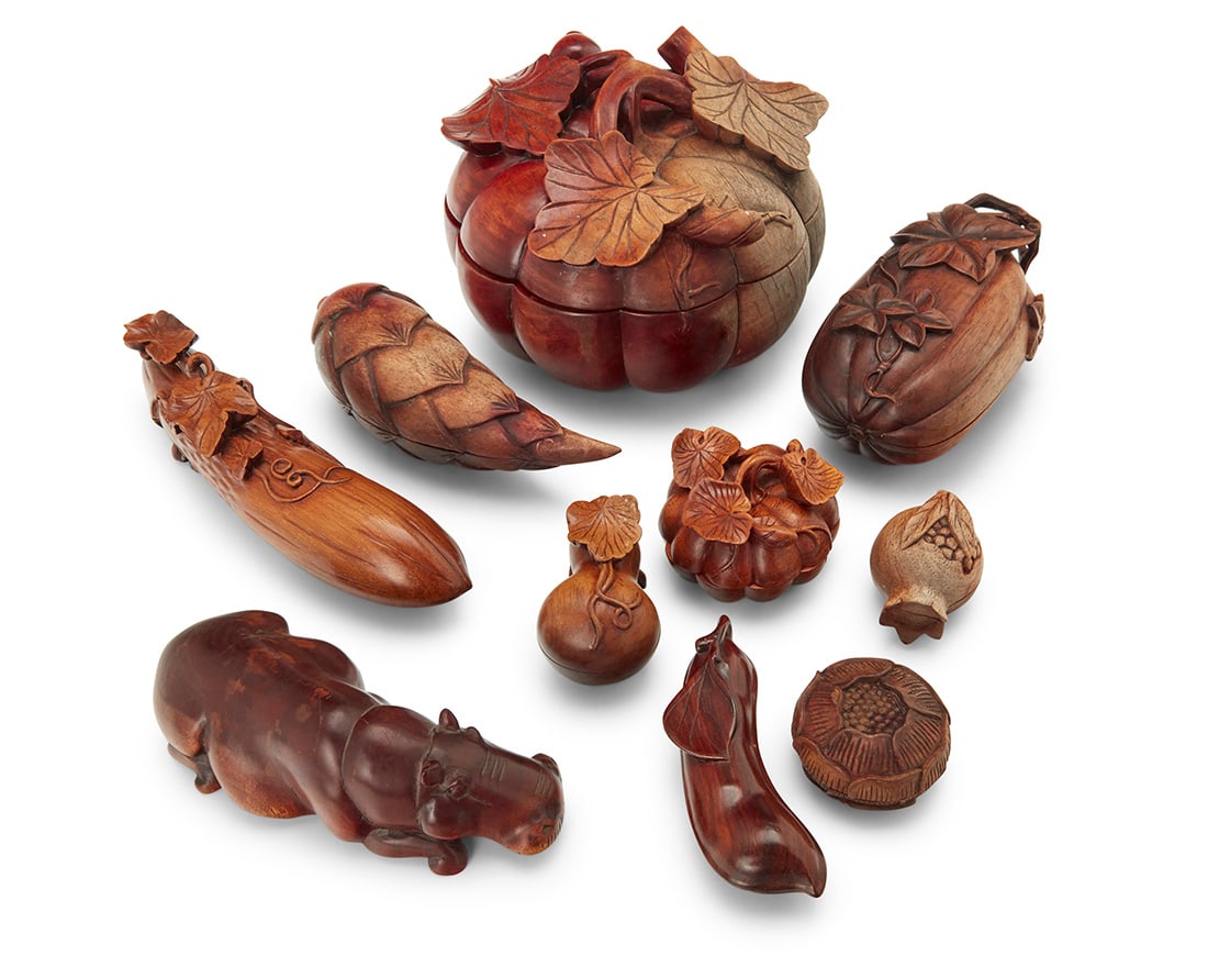 A group of Japanese carved wood vegetable and fruit form boxes: A group of Japanese carved wood vegetable and fruit form boxes Late 19th/20th century Comprising various gourds, a pinecone, and a pomegranate, together with a carved model of a hippopotamus 9 pieces