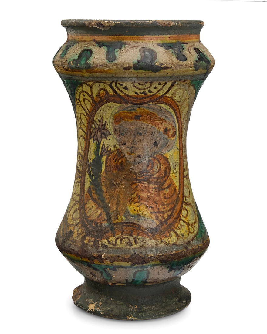 An Italian maiolica albarello: An Italian maiolica albarello 17th/18th century, possibly Sicilian The glazed pottery footed jar possibly depicting Saint Joseph with a lily 9.5" H x 5.375" Dia.