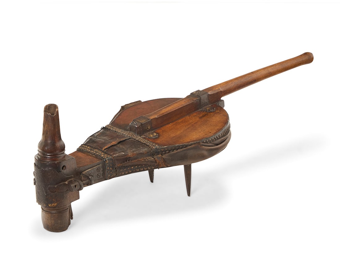A blacksmith bellows: A blacksmith bellows 19th/20th century Wrought-iron, leather, and carved wood with metal tacking 14.5" H x 45.5" W x 16" D