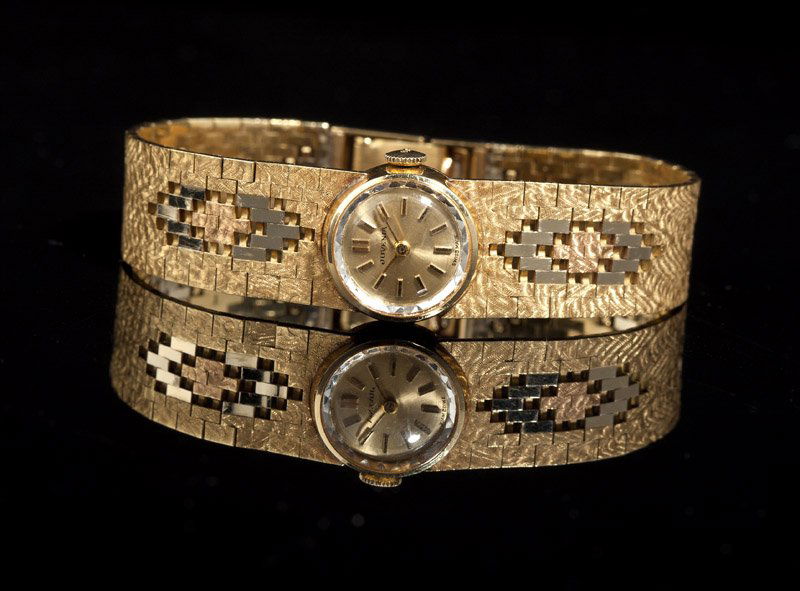 A ladies Juvenia tri-color gold wristwatch: The circular champagne dial signed Juvenia with applied baton hour markers, attached to 17 jwl movement, signed Juvenia, Cal. 105S, within an 18K gold case, marked '18K .750', with integrated 18K gold