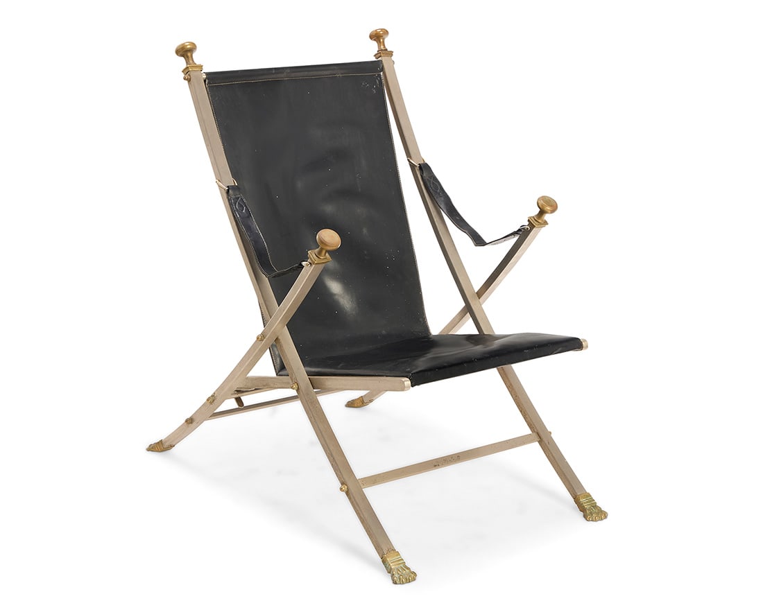 A folding campaign chair attributed to Maison Jansen: A folding campaign chair attributed to Maison Jansen Circa 1960s The steel X-frame with brass paw feet and upper terminal knobs, with leather seat cushion, sling back, and armrests 36.75" H x 24.75"