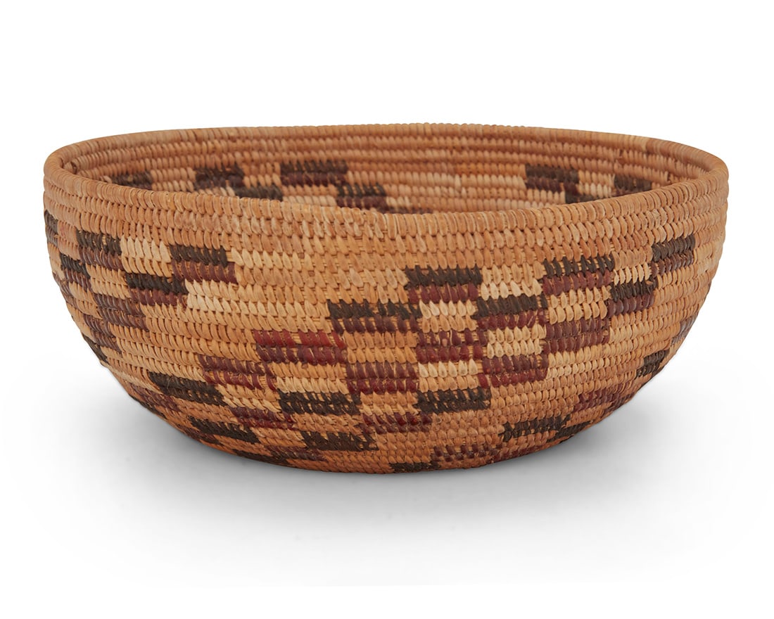 A polychrome Yokuts basketry bowl: A polychrome Yokuts basketry bowl Mid-20th century; Central California A coiled low bowl with four swirled stepped 'whirlwind' motifs 3" H x 7.125" Dia. Provenance: Private collection, San