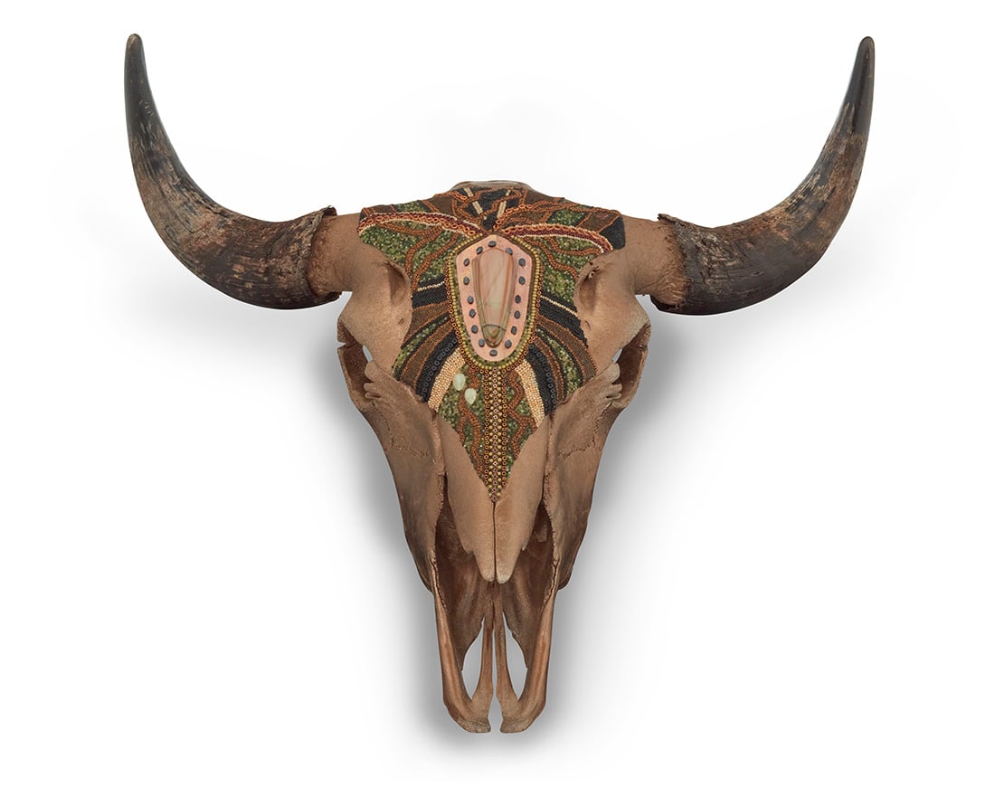 Suzanne Schmaltz (b. 20th century, American), A beaded American bison skull, early 21st century: Suzanne Schmaltz (b. 20th century, American) A beaded American bison skull, early 21st century Unsigned The gold-toned skull mounted with glass and metal beads, hardstone accents, and hammered copper