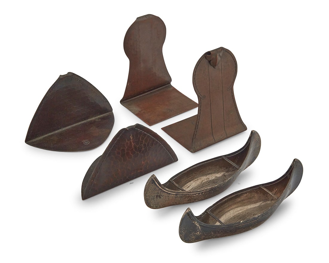 A group of Arts & Crafts metalwork items: A group of Arts & Crafts metalwork items Late 19th/early 20th century Bookends impressed with Roycroft orb; canoes with English hallmarks for sterling, 1896, and maker: S.I.L.D [Stokes & Ireland;