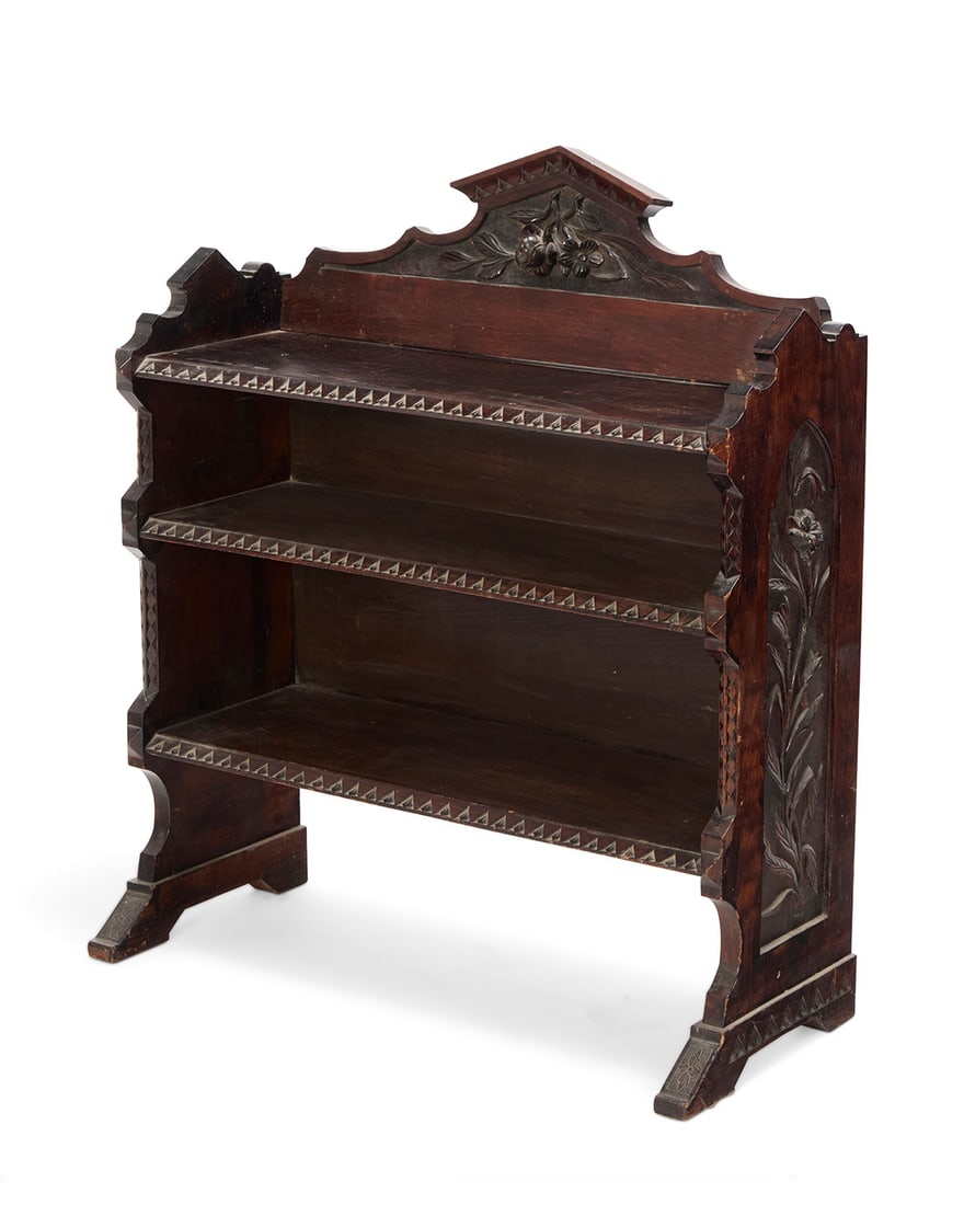 An American carved walnut bookcase: An American carved walnut bookcase Late 19th century Carved with calla lilies in relief to sides and a floral element in relief to pediment, with stylized trimming to front edges 38.25" H x 33.25" W