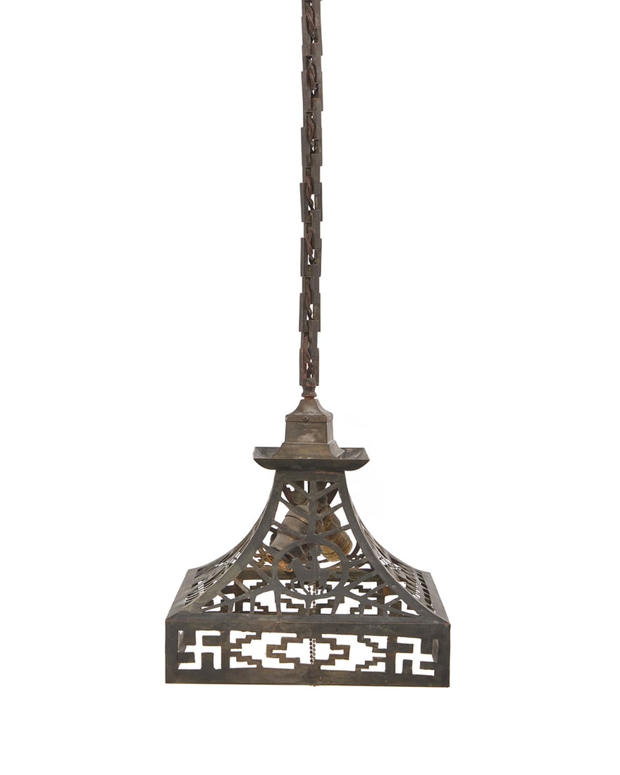 An Arts & Crafts pendant lamp: An Arts & Crafts pendant lampEarly 20th centuryWith two lights and reticulated brass shade depicting Southwest/Native American themes to each panel and skirt, designed for slumped/slag glass or mica,