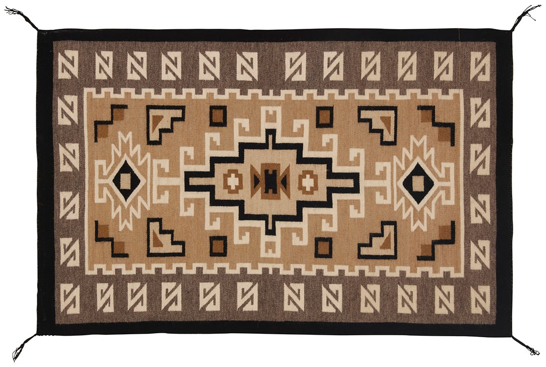 A framed Navajo Two Grey Hills textile: A framed Navajo Two Grey Hills textileMid/late 20th century, DineWoven in grey, tan, black, and cream wool with an elaborate hooked diamond to center, sawtooth diamonds to each end and an elaborate ho