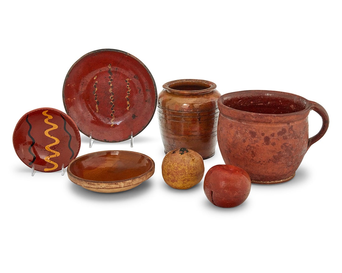 A group of Pennsylvania redware pottery items: A group of Pennsylvania redware pottery items Late 19th century-late 20th century One dish incised: R Breininger / Robesonia Pa / June 1977 Comprising two apple-form money banks, two crocks, two