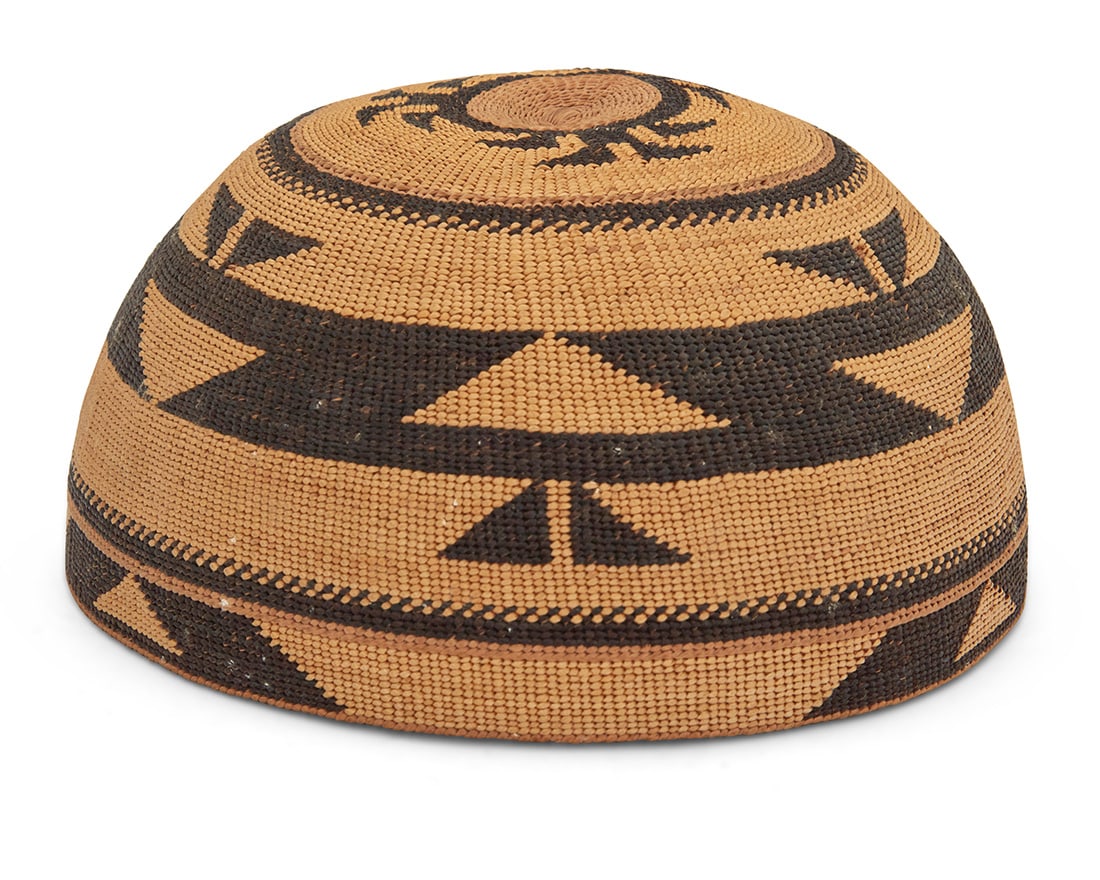 A polychrome Hupa/Yurok/Karuk basketry hat: A polychrome Hupa/Yurok/Karuk basketry hatEarly/mid-20th century; Northern CaliforniaA twined hat with imbricated triangular and hooked banding to sides and clusters of triangular 'foot' motifs to cro