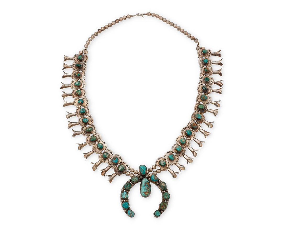 A Southwest silver and turquoise 'box & bow' squash blossom necklace: A Southwest silver and turquoise 'box & bow' squash blossom necklace Mid-20th century Unmarked A double strand silver bead necklace of twenty-eight 'box and bow' blossoms, each with set nugget