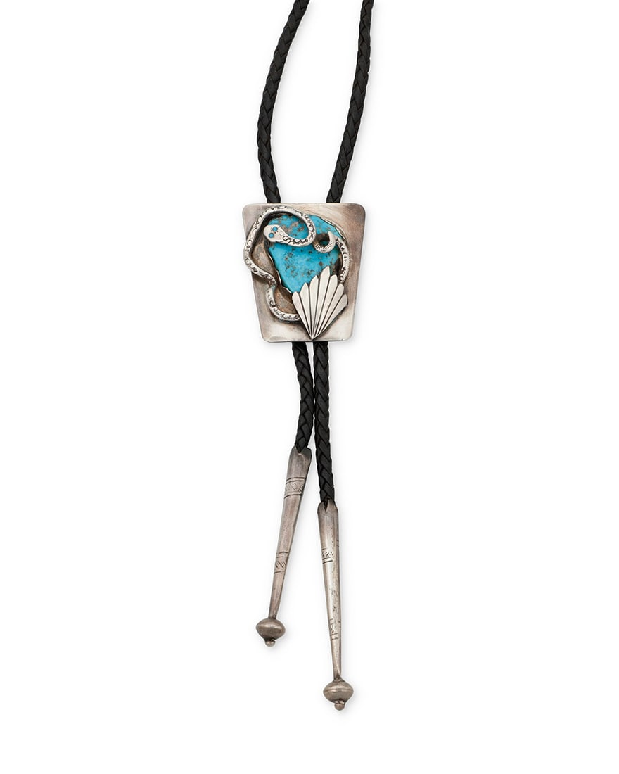 A Zuni silver and turquoise bolo tie, attributed to Dan Simplico: A Zuni silver and turquoise bolo tie, attributed to Dan Simplico Attributed to Dan Simplicio (1917-1970, Zuni) Stamped: Sterling A sterling silver bolo tie featuring a trapezoidal slide with a large