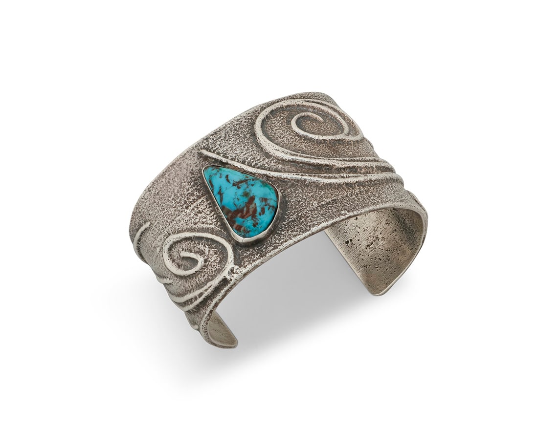 A Preston Monongye Hopi silver and turquoise cuff bracelet: A Preston Monongye Hopi silver and turquoise cuff bracelet Preston Monongye (1927-1987, Mission/Hopi) Mid/late 20th century Marked to plaque with artist's Peyote bird picto A wide tapered chunky cuff
