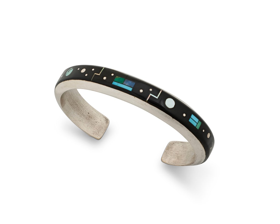 An Albert Yazzie Navajo sterling silver and channel set inlay cuff bracelet: An Albert Yazzie Navajo sterling silver and channel set inlay cuff bracelet Albert Yazzie (b.1954, Dine) Stamped: AY / Sterling A narrow cuff with delicate multistage silver, turquoise, lapis lazuli,