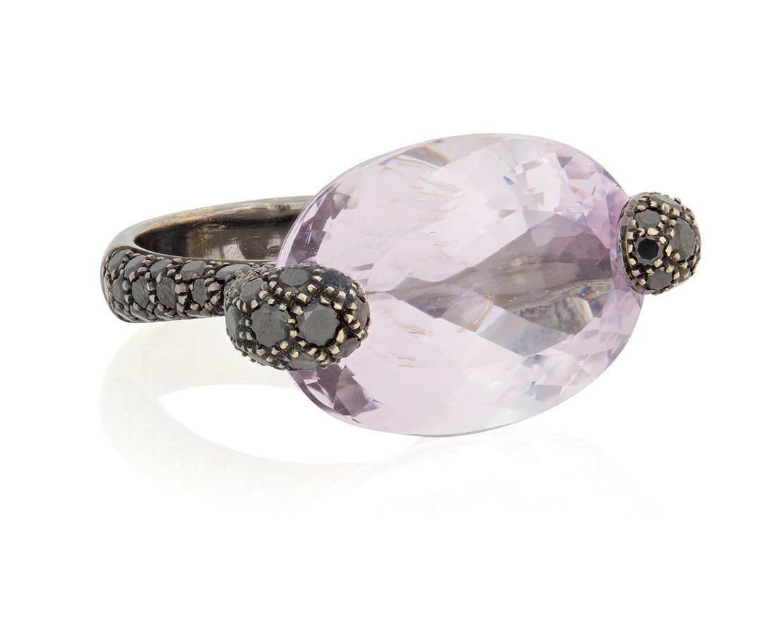 Giorgio Armani: A Black Rhodium Plated 18K White Gold, Kunzite, and Black Diamond Ring: Giorgio Armani: A Black Rhodium Plated 18K White Gold, Kunzite, and Black Diamond Ring Centering an oval kunzite measuring approximately 24.00 x 16.80 mm accented by round black diamonds, with