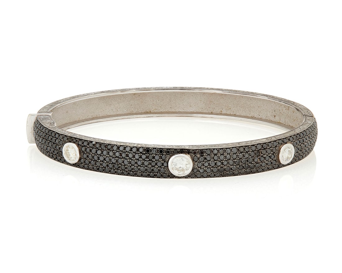 A 14K White Gold, Black Diamond and Diamond Bangle Bracelet: A 14K White Gold, Black Diamond and Diamond Bangle Bracelet Featuring three round diamonds weighing approximately 0.75 carat, accented by pave-set black diamonds weighing approximately 3.39 carats,