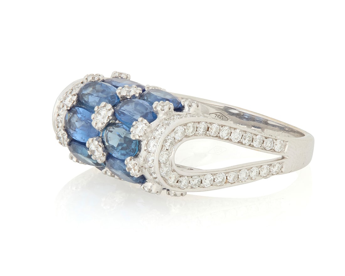 An 18K White Gold, Sapphire and Diamond Ring: An 18K White Gold, Sapphire and Diamond Ring Featuring ten oval sapphires weighing approximately 5.46 carats, accented by round diamonds weighing approximately 1.89 carats set in a high-profile