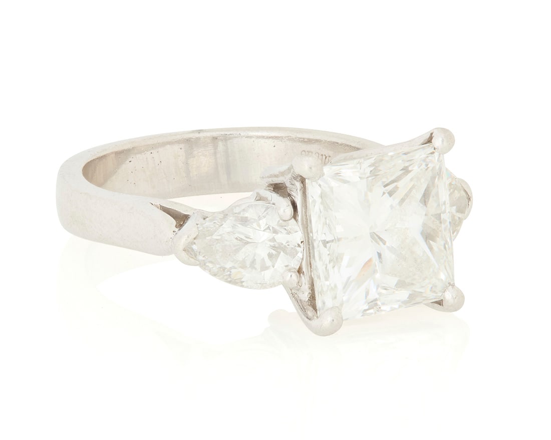 A Platinum and Diamond Ring: A Platinum and Diamond RingCentering a princess-cut diamond weighing 4.07 carats, flanked by two pear-shaped diamonds weighing approximately 1.30 carats, signed MarcusSize: 6 1/49.9 grams grossAccompa