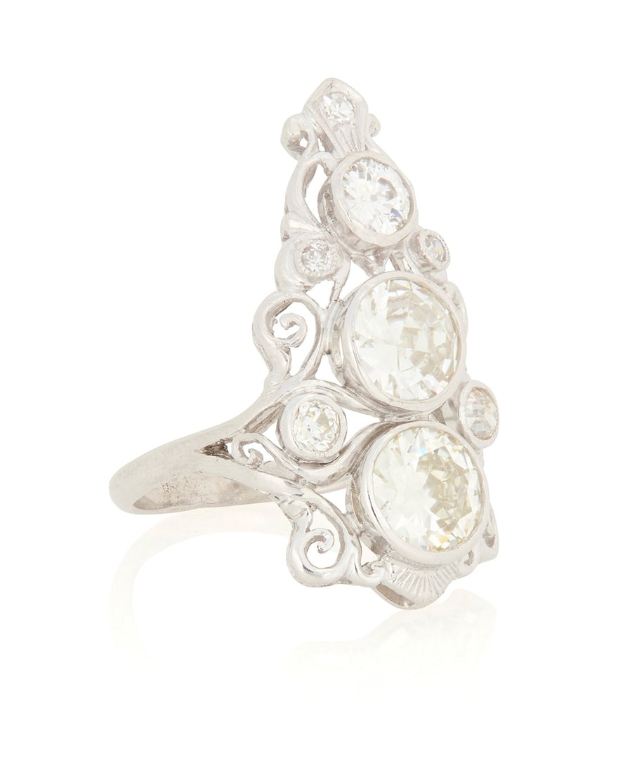 A Platinum and Diamond Ring: A Platinum and Diamond Ring Of a scrolling design centering three graduated round diamonds weighing approximately 0.32 carat, 0.81 carat and 1.02 carat, with old European-cut diamond accents Size: 6